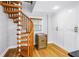 Wooden spiral staircase next to wine cooler and built in pantry in light and airy kitchen at 1628 Long Bow Ln, Clearwater, FL 33764