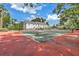 Well-maintained tennis court provides recreation and exercise, set against a backdrop of a beautiful home at 1628 Long Bow Ln, Clearwater, FL 33764