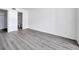 A bedroom features modern gray wood flooring, white walls, and an entrance to the bathroom at 2049 Skimmer W Ct # 311, Clearwater, FL 33762