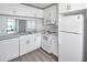Bright kitchen with white cabinetry, modern appliances and solid surface countertops at 2049 Skimmer W Ct # 311, Clearwater, FL 33762