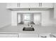 Modern kitchen with white countertops offering an open view of the living room at 2049 Skimmer W Ct # 311, Clearwater, FL 33762