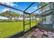 Screened-in patio with brick floors, views of green lawns, and mature trees at 2049 Skimmer W Ct # 311, Clearwater, FL 33762