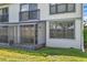 A screened-in patio with white siding, an outdoor light, and a green grass at 2049 Skimmer W Ct # 311, Clearwater, FL 33762