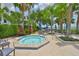 Community hot tub surrounded by lush landscaping, tables, chairs, and umbrellas at 2201 Bay Club Cir, Tampa, FL 33607