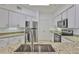 Well-lit kitchen featuring stainless steel appliances, white cabinets and granite countertops at 2201 Bay Club Cir, Tampa, FL 33607