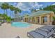 Community pool with tanning chairs, a waterfall feature, and tropical palm trees at 2201 Bay Club Cir, Tampa, FL 33607