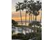 Stunning waterfront view overlooking a pool and spa area, enhanced by swaying palm trees and a colorful sunset at 2201 Bay Club Cir, Tampa, FL 33607