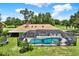 Aerial view showcases a screened-in pool and spa, skylights, and lush greenery surrounding the property at 2515 Pemberton Creek Dr, Seffner, FL 33584
