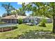 Backyard view showcasing a screened-in pool area, a trampoline, and lush greenery at 2515 Pemberton Creek Dr, Seffner, FL 33584