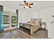 Bright bedroom with hardwood floors, a ceiling fan, and sliding glass doors to a screened patio at 2515 Pemberton Creek Dr, Seffner, FL 33584