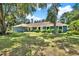 Charming single-story home with large windows, mature trees, and a well-manicured lawn at 2515 Pemberton Creek Dr, Seffner, FL 33584