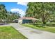 Inviting single-story home with a long driveway, lush landscaping, and mature trees on a sprawling lot at 2515 Pemberton Creek Dr, Seffner, FL 33584