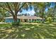 Charming one-story home with lush lawn, mature trees, and a welcoming front entrance at 2515 Pemberton Creek Dr, Seffner, FL 33584