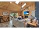 Cozy living room with wood-paneled ceiling, skylights, stone fireplace, and sliding door access to the outdoor area at 2515 Pemberton Creek Dr, Seffner, FL 33584
