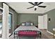 Relaxing main bedroom features a ceiling fan, wood-look floors, and access to the screened-in pool area at 2515 Pemberton Creek Dr, Seffner, FL 33584