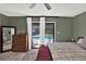 View of the main bedroom showing access to the screened-in pool, a wood dresser and stylish decor at 2515 Pemberton Creek Dr, Seffner, FL 33584