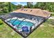 Aerial view of a screened-in pool and spa area, skylights, and seating for relaxing by the water at 2515 Pemberton Creek Dr, Seffner, FL 33584