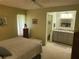 Bedroom with a view to the bathroom, offering carpet flooring, and a ceiling fan at 2588 Laurelwood Dr # 16A, Clearwater, FL 33763