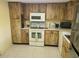 Traditional kitchen featuring wood cabinets, white appliances and tiled floors at 2588 Laurelwood Dr # 16A, Clearwater, FL 33763