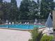 Community pool area with lounge chairs and umbrellas at 2588 Laurelwood Dr # 16A, Clearwater, FL 33763