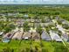 Residential aerial view of neighborhood showcasing lush trees and community pond at 27652 Sky Lake Cir, Wesley Chapel, FL 33544