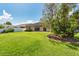 Lush backyard featuring a spacious lawn and large tree near the edge of the lawn at 27652 Sky Lake Cir, Wesley Chapel, FL 33544