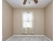 This carpeted bedroom has tan walls, a ceiling fan and a window at 27652 Sky Lake Cir, Wesley Chapel, FL 33544
