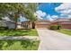 Charming single-story home with well-maintained lawn, mature tree, and attached two-car garage at 27652 Sky Lake Cir, Wesley Chapel, FL 33544