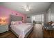 This bedroom features a striking pink accent wall, hardwood flooring, and a decorative ceiling fan at 2804 Countryside Blvd # 4, Clearwater, FL 33761