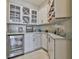 Charming bar area featuring custom white cabinetry, wine rack, granite countertops, and stainless steel cooler at 2866 Quail Crest Ct, Valrico, FL 33594