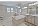 Bright bathroom featuring a large soaking tub, dual vanities, and natural light from windows at 2866 Quail Crest Ct, Valrico, FL 33594