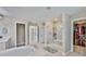 Bathroom showcasing a soaking tub, walk-in shower and convenient access to a spacious walk-in closet at 2866 Quail Crest Ct, Valrico, FL 33594