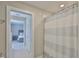 Bathroom with a shower curtain and a glimpse of a well-lit bedroom in the background at 2866 Quail Crest Ct, Valrico, FL 33594