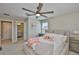 Comfortable bedroom featuring a ceiling fan, window, and access to a full bathroom at 2866 Quail Crest Ct, Valrico, FL 33594