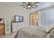 Bright bedroom with a large dresser, TV, ceiling fan, and connecting bathroom at 2866 Quail Crest Ct, Valrico, FL 33594