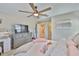 Inviting bedroom showcasing a fan, dresser with TV, and hallway access at 2866 Quail Crest Ct, Valrico, FL 33594