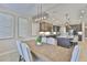Elegant dining room with a wooden table, upholstered chairs, modern lighting, and seamless flow to the gourmet kitchen at 2866 Quail Crest Ct, Valrico, FL 33594