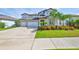 Charming two-story home with a three-car garage, a lush lawn, and vibrant landscaping at 2866 Quail Crest Ct, Valrico, FL 33594