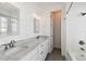 Well-lit bathroom with double sinks, white cabinets, stylish mirrors, and subway tile tub at 3111 W De Leon St # 9, Tampa, FL 33609