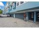 Charming condo exterior featuring blue paint, grey garage doors, and well maintained landscaping at 3111 W De Leon St # 9, Tampa, FL 33609