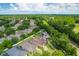 High-angle showcases a community of homes nestled among lush greenery, under a bright blue sky at 320 Roxbury Crossing Ct, Valrico, FL 33594