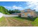 Large backyard with a white fence, showcasing plenty of space for outdoor activities, and neighboring homes in the background at 320 Roxbury Crossing Ct, Valrico, FL 33594