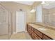 Bathroom with a double sink vanity, granite countertops, and a walk-in shower with glass doors at 320 Roxbury Crossing Ct, Valrico, FL 33594