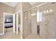 Bathroom with tiled walk-in shower, tiled flooring and doors leading to the toilet and bedroom at 320 Roxbury Crossing Ct, Valrico, FL 33594