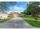 Inviting two-story home featuring a well-manicured lawn and a long driveway leading to an attached two-car garage at 320 Roxbury Crossing Ct, Valrico, FL 33594
