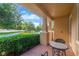 Charming tiled front porch with table and chairs, framed by verdant greenery, offering a relaxing outdoor space at 320 Roxbury Crossing Ct, Valrico, FL 33594