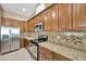 This kitchen features stainless steel appliances and warm wood cabinetry at 320 Roxbury Crossing Ct, Valrico, FL 33594