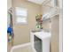 Bright laundry room features a white washer and dryer, storage shelves, and a window offering natural light at 320 Roxbury Crossing Ct, Valrico, FL 33594