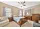 Comfortable main bedroom with wood furniture, soft lighting, and a ceiling fan at 320 Roxbury Crossing Ct, Valrico, FL 33594