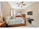 Well-lit main bedroom featuring a bed, dresser, TV, and neutral decor at 320 Roxbury Crossing Ct, Valrico, FL 33594